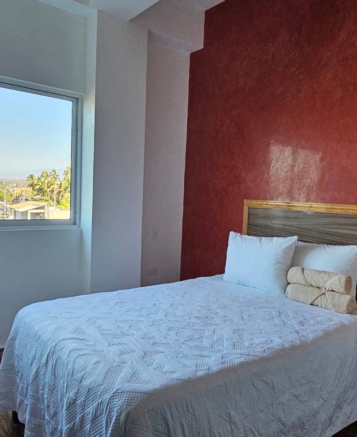 Habitación matrimonial con pared roja